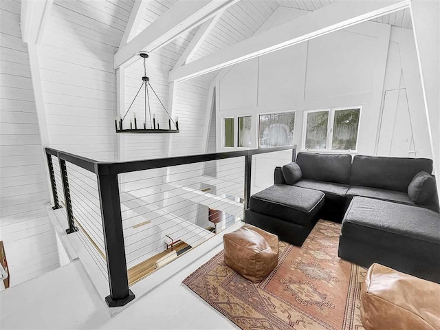 living area with a chandelier, high vaulted ceiling, wooden ceiling, wood walls, and beam ceiling