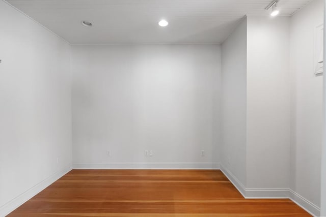 spare room featuring light wood-style floors, baseboards, track lighting, and recessed lighting