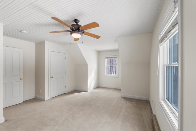 bonus room featuring ceiling fan, baseboards, and light colored carpet