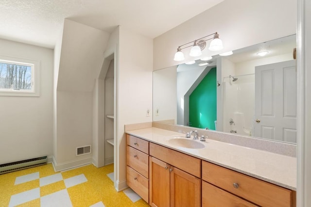 bathroom with vanity, visible vents, a shower, baseboard heating, and tile patterned floors