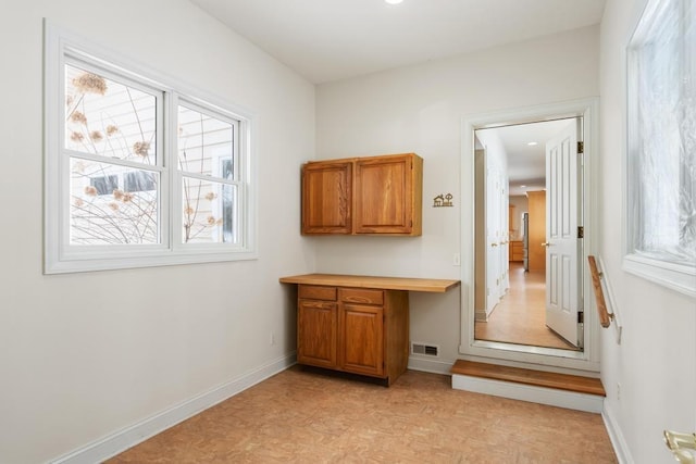 interior space with baseboards, visible vents, and a wealth of natural light