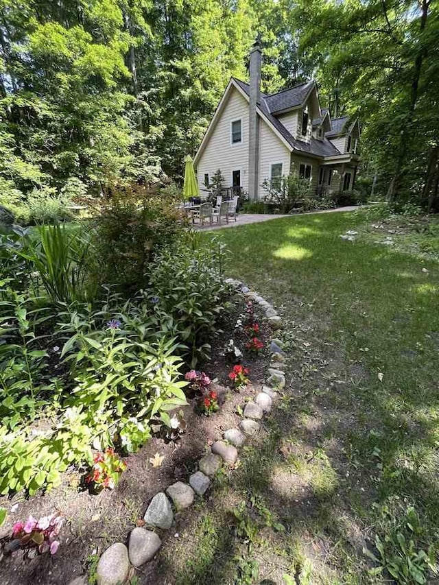 view of yard featuring a patio and a wooded view