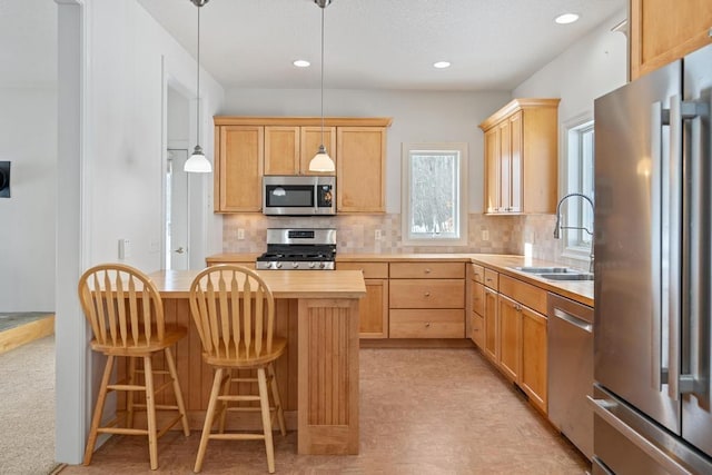 kitchen featuring stainless steel appliances, butcher block counters, decorative backsplash, light brown cabinets, and a sink