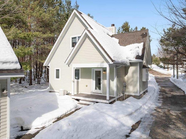 view of front of home featuring a porch and a chimney