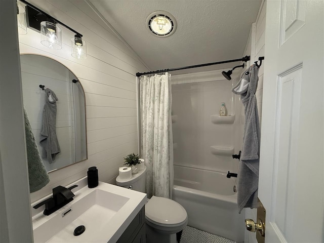 bathroom featuring a textured ceiling, toilet, wooden walls, vanity, and shower / bath combo