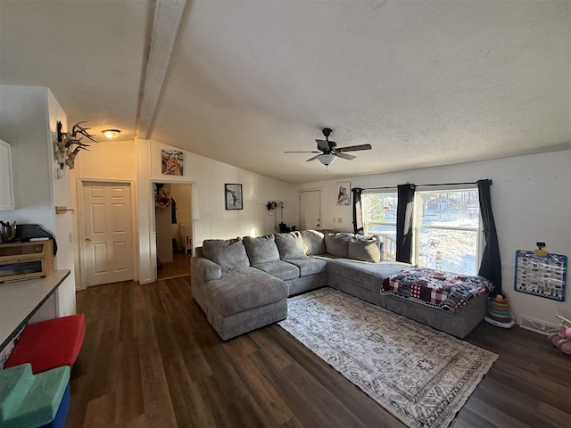 living room with lofted ceiling with beams, a textured ceiling, dark wood finished floors, and a ceiling fan