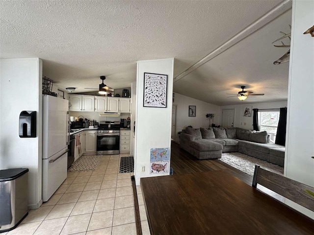 kitchen with dishwasher, open floor plan, freestanding refrigerator, stainless steel range oven, and light tile patterned flooring