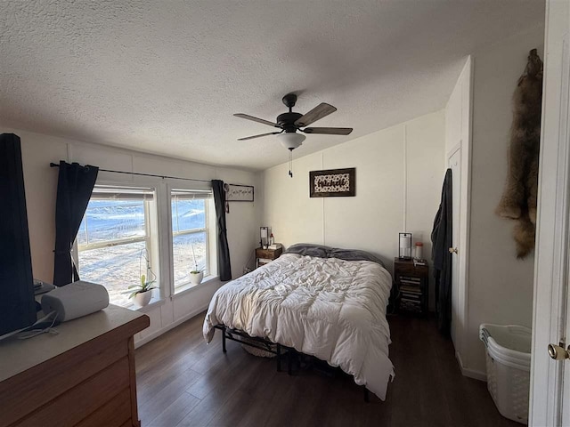 bedroom with a textured ceiling, a ceiling fan, vaulted ceiling, and wood finished floors