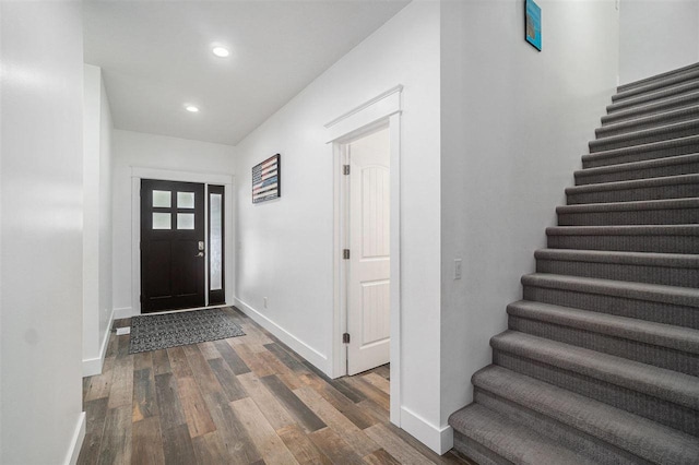 foyer featuring stairs, recessed lighting, wood finished floors, and baseboards