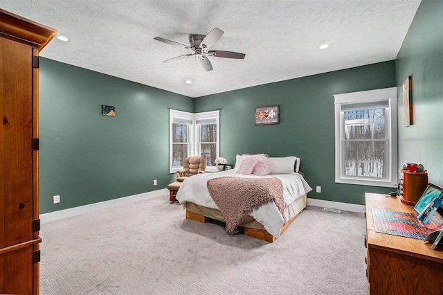 bedroom with light carpet, multiple windows, and baseboards