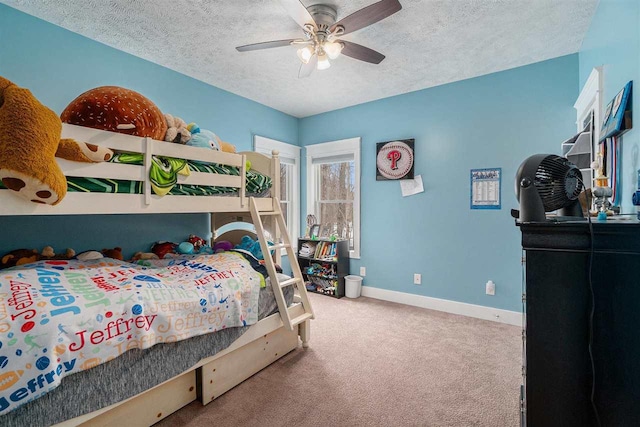 carpeted bedroom with a textured ceiling, a ceiling fan, and baseboards