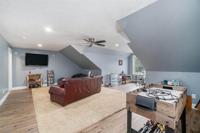 living area with vaulted ceiling, light wood-style flooring, and baseboards