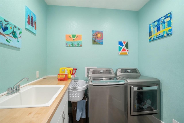 clothes washing area featuring a sink and washer and clothes dryer