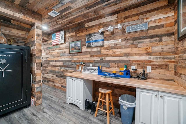 bar with wood ceiling, wood walls, and light wood-style flooring