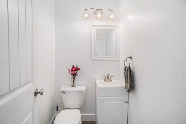 bathroom with toilet, baseboards, and vanity