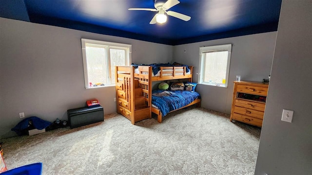 bedroom with a ceiling fan and carpet