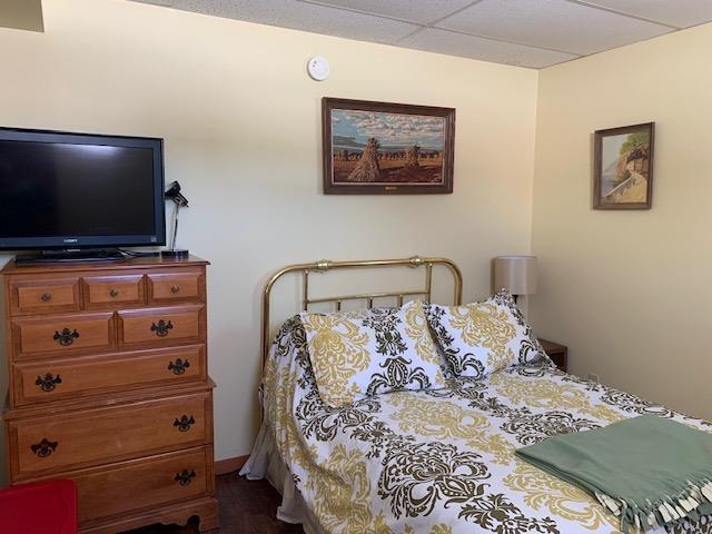 bedroom with dark wood-style floors and a paneled ceiling