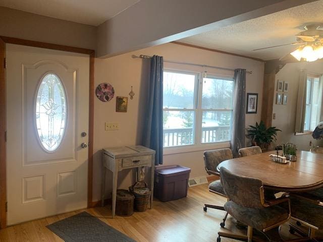 foyer with light wood finished floors and a ceiling fan