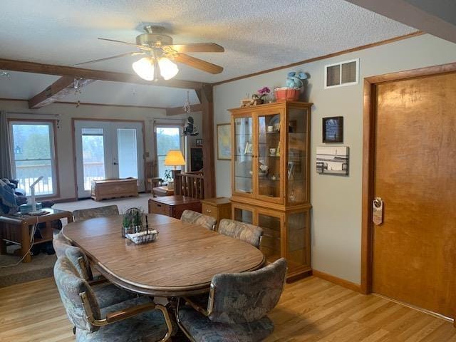 dining space featuring plenty of natural light, light wood-style flooring, visible vents, and a textured ceiling