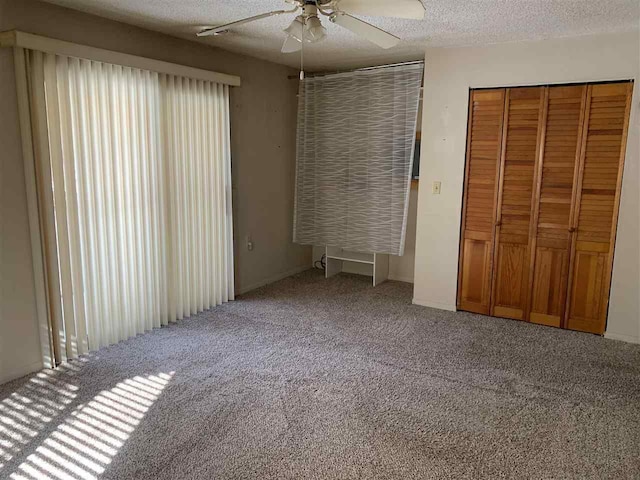 unfurnished bedroom with carpet floors, a closet, a textured ceiling, and a ceiling fan