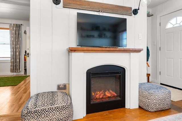 interior details featuring a glass covered fireplace and wood finished floors