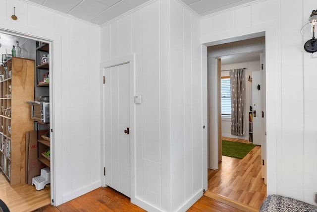 hall featuring light wood-type flooring and crown molding