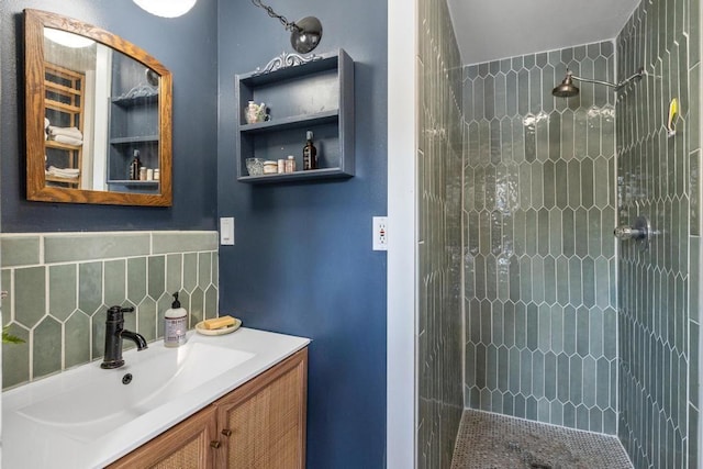 full bath with a tile shower, backsplash, and vanity