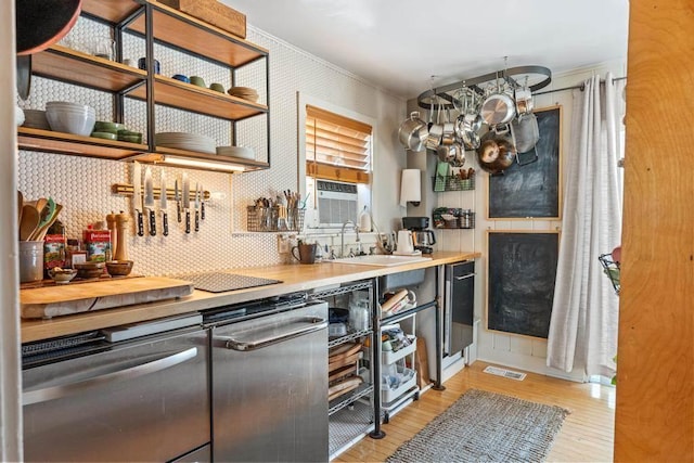 kitchen featuring visible vents, decorative backsplash, light wood-style floors, a chandelier, and a sink