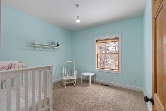 carpeted bedroom with a nursery area, visible vents, and baseboards