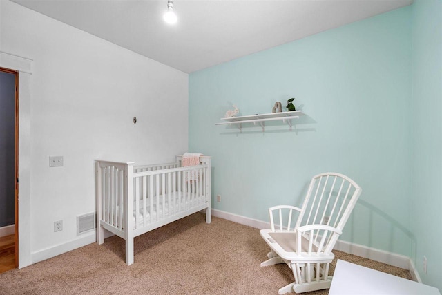 carpeted bedroom with a crib, baseboards, and visible vents