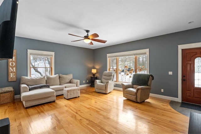 living room with a wealth of natural light, baseboards, and wood finished floors