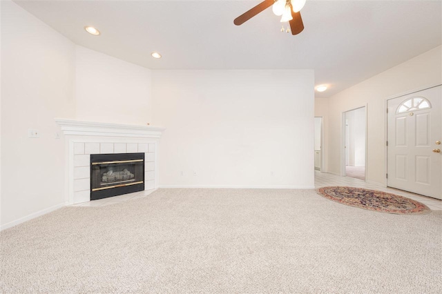 unfurnished living room featuring recessed lighting, baseboards, light colored carpet, and a tiled fireplace