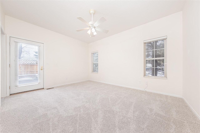 spare room featuring baseboards, a ceiling fan, vaulted ceiling, and carpet flooring