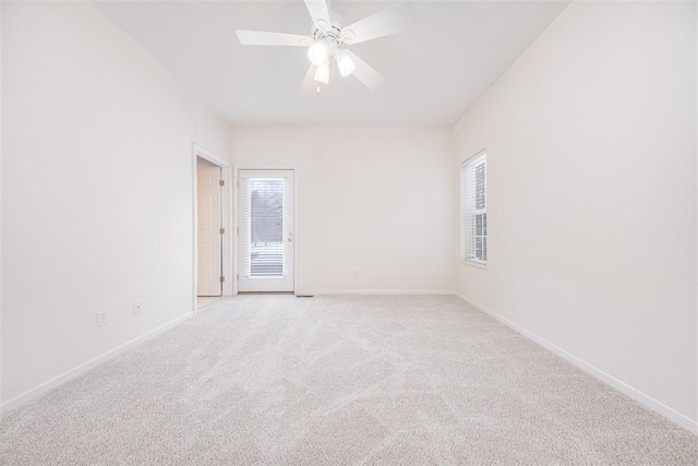 unfurnished room featuring baseboards, a wealth of natural light, and light colored carpet