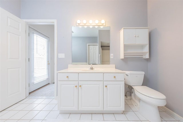 bathroom with toilet, tile patterned flooring, baseboards, and vanity