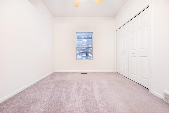 unfurnished bedroom with ceiling fan, a closet, carpet flooring, and baseboards