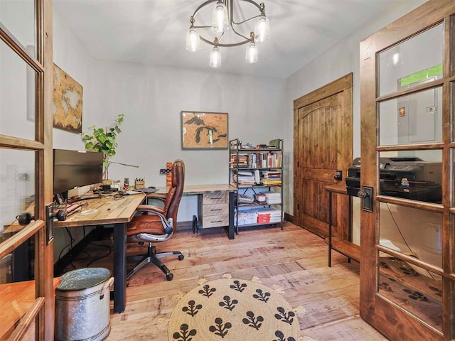 office area with baseboards, a notable chandelier, and hardwood / wood-style floors