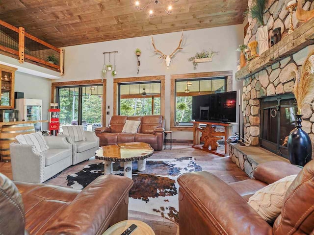 living area with high vaulted ceiling, a stone fireplace, hardwood / wood-style flooring, and wood ceiling