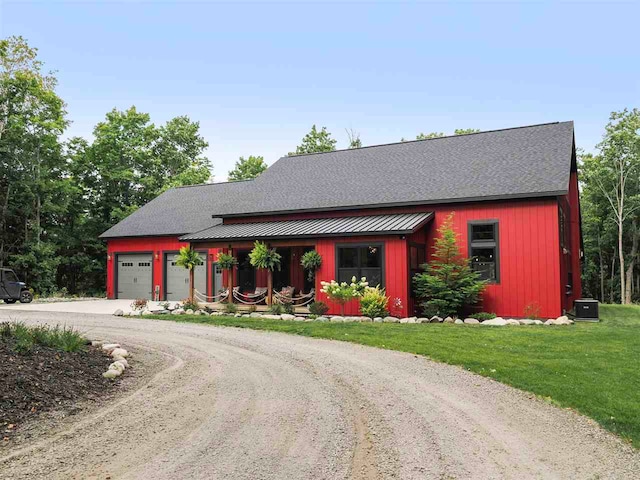 view of front of property with driveway, metal roof, an attached garage, a standing seam roof, and a front yard