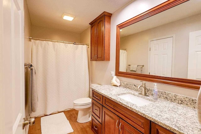 full bath featuring curtained shower, vanity, toilet, and wood finished floors