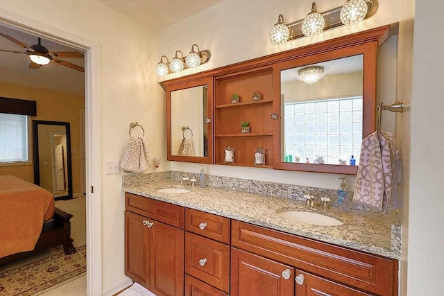 bathroom featuring ceiling fan, a sink, and double vanity