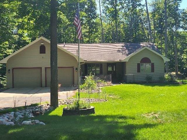 single story home featuring an attached garage, driveway, and a front lawn