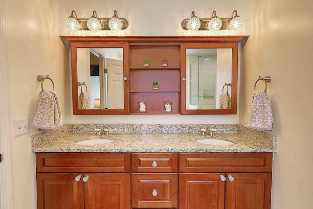 full bathroom with double vanity, walk in shower, and a sink