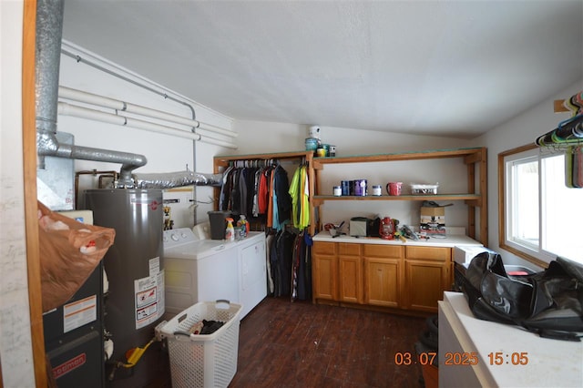 clothes washing area featuring cabinet space, water heater, dark wood-style flooring, and washing machine and clothes dryer