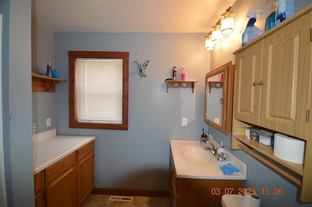 bathroom with visible vents, vanity, and baseboards