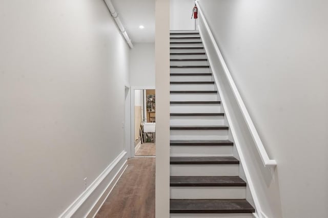 stairs with baseboards and a towering ceiling