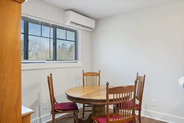 dining space featuring a wall mounted air conditioner, baseboards, and wood finished floors