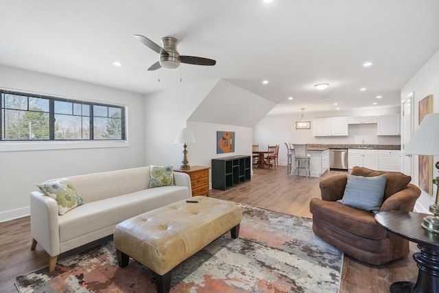 living area featuring recessed lighting, light wood-style floors, baseboards, and ceiling fan