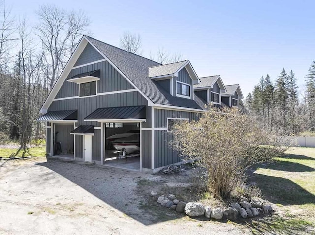 view of front of property with metal roof, board and batten siding, roof with shingles, and a standing seam roof