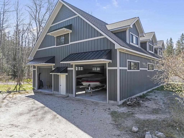 view of home's exterior featuring board and batten siding, a shingled roof, and a standing seam roof